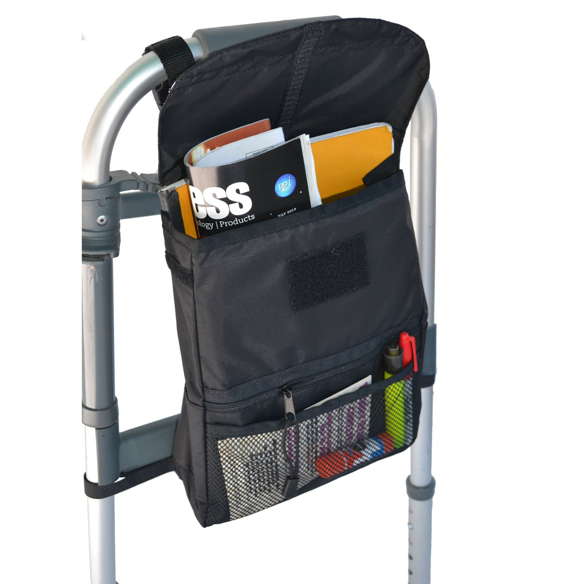 Diestco Deluxe Walker Bag strapped to the side of a folding walker, loaded with magazines in the main compartment, a zippered pocket, and pens and papers in the mesh pocket