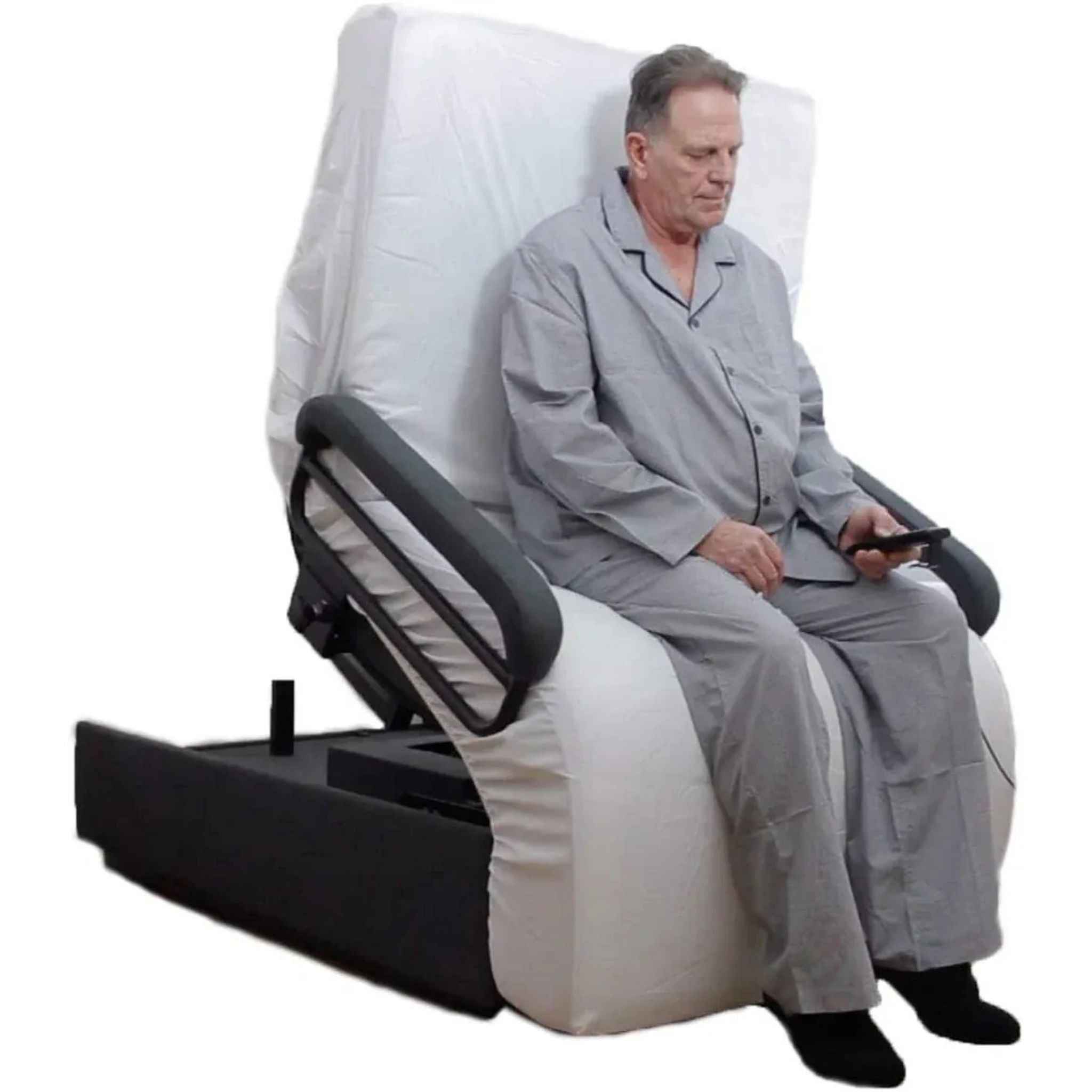 Man sitting upright on an Envyy Sleep-to-Stand adjustable bed with padded side rails and powered sit-to-stand positioning assistance, holding a remote control.
