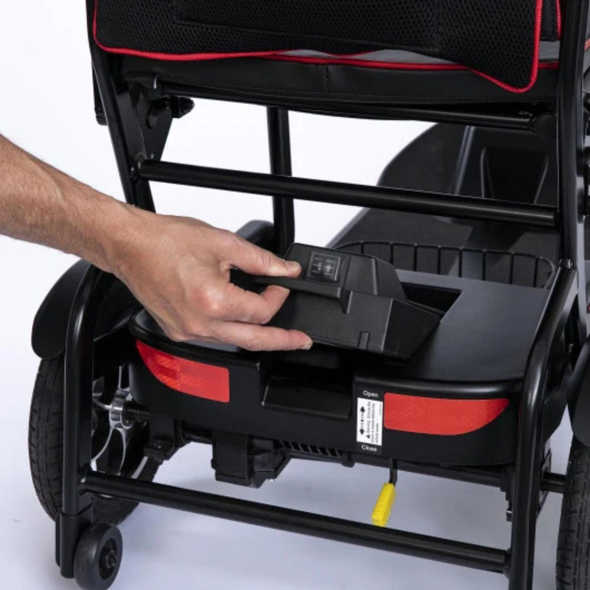 Hand lifting the removable lithium battery pack by its handle from the rear of the Feather Scooter