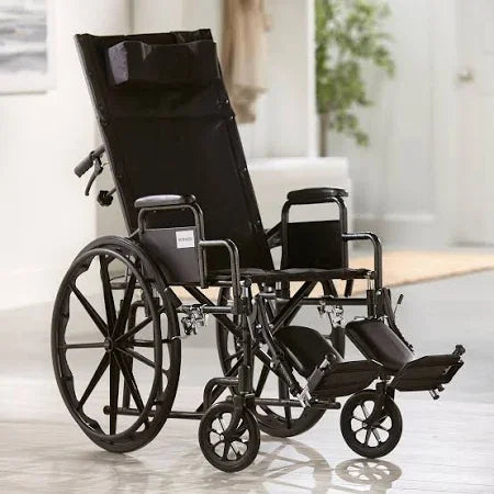 Reclining black lightweight wheelchair with elevated leg rests in a bright living room