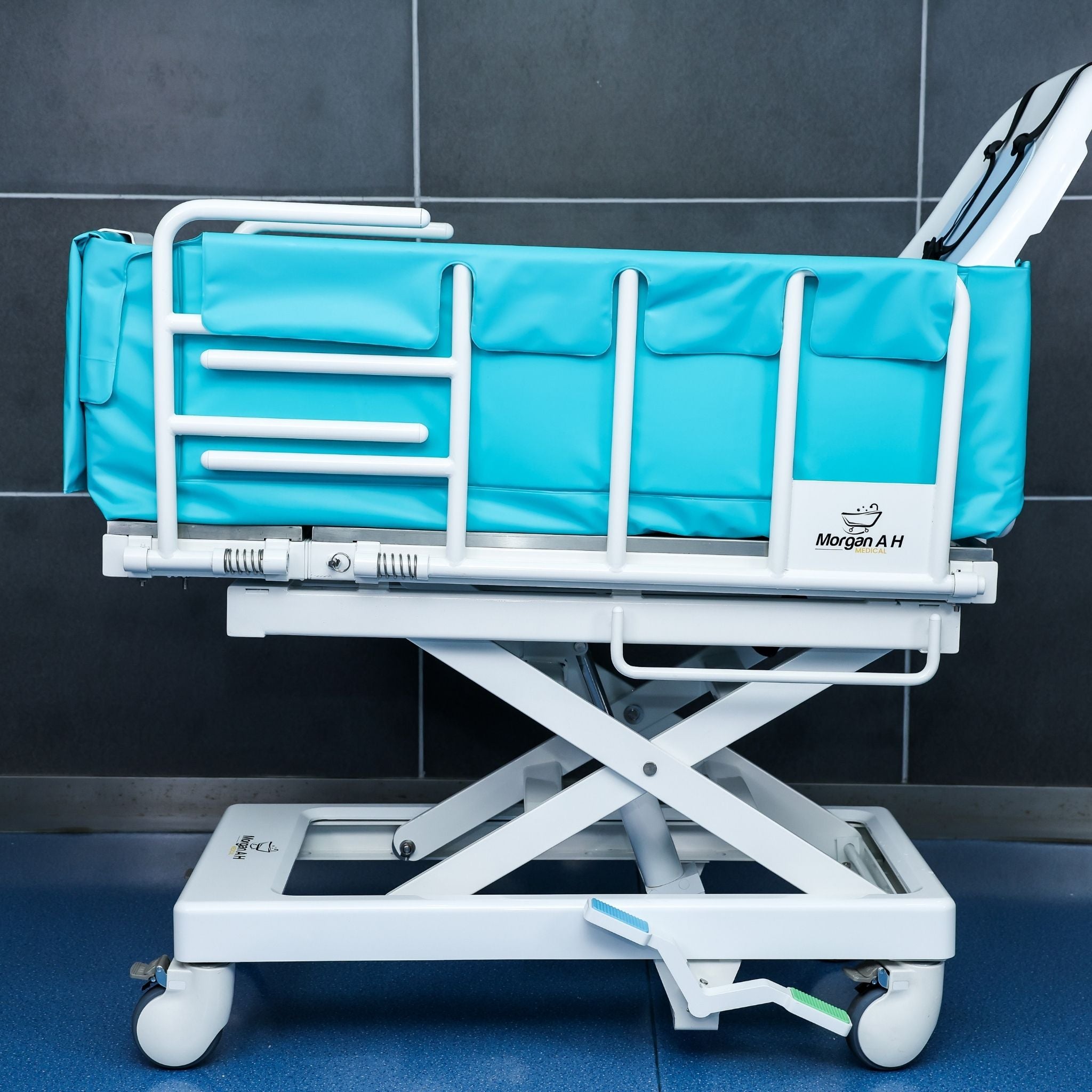 Side view of Morgan AH Medical bathing trolley with padded safety rails and lift frame
