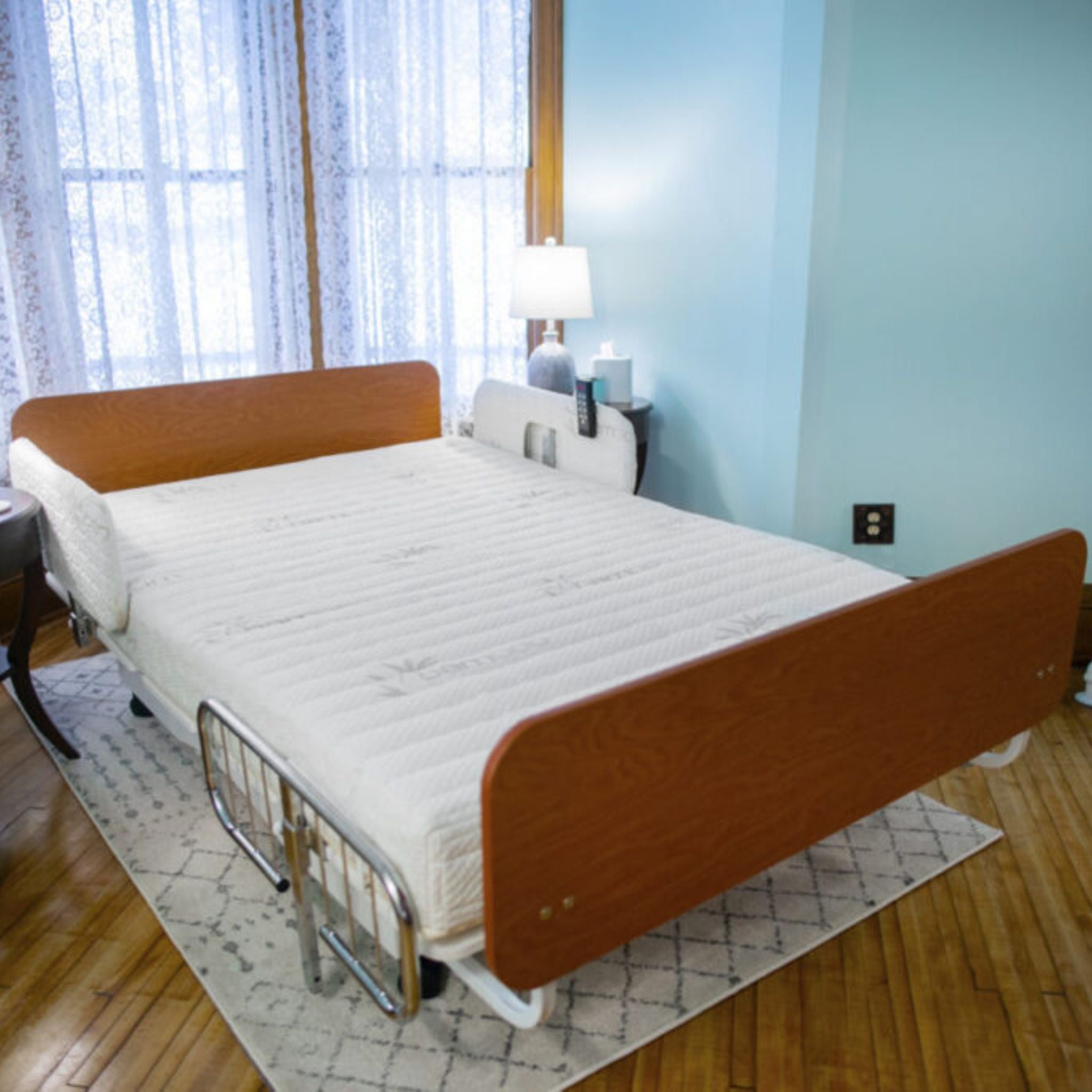 Transfer Master Night Rider HD bariatric bed with cherry panels and a half rail set up in a home bedroom