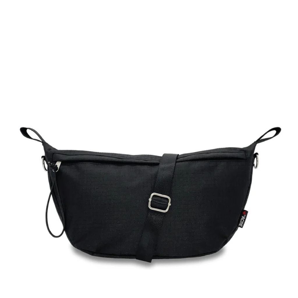 Front view of the black byACRE Pocket Bag with its adjustable shoulder strap, buckle, and zip pull