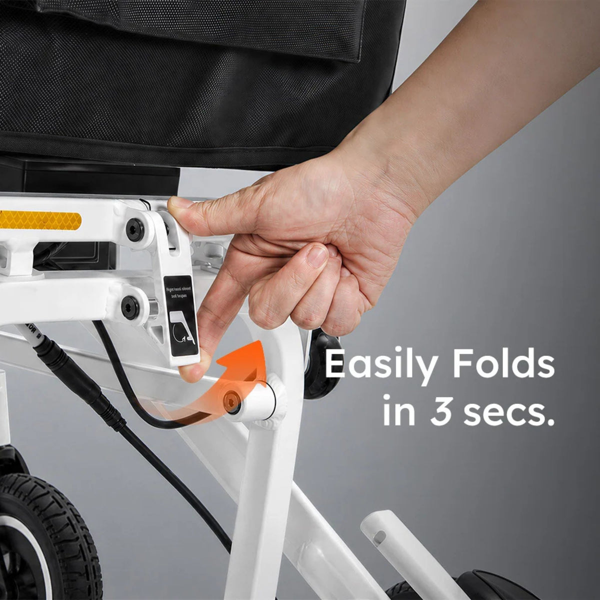 Hand releasing the redesigned frame lock on the OAS Air Pro 2027 electric wheelchair, which folds in 3 seconds