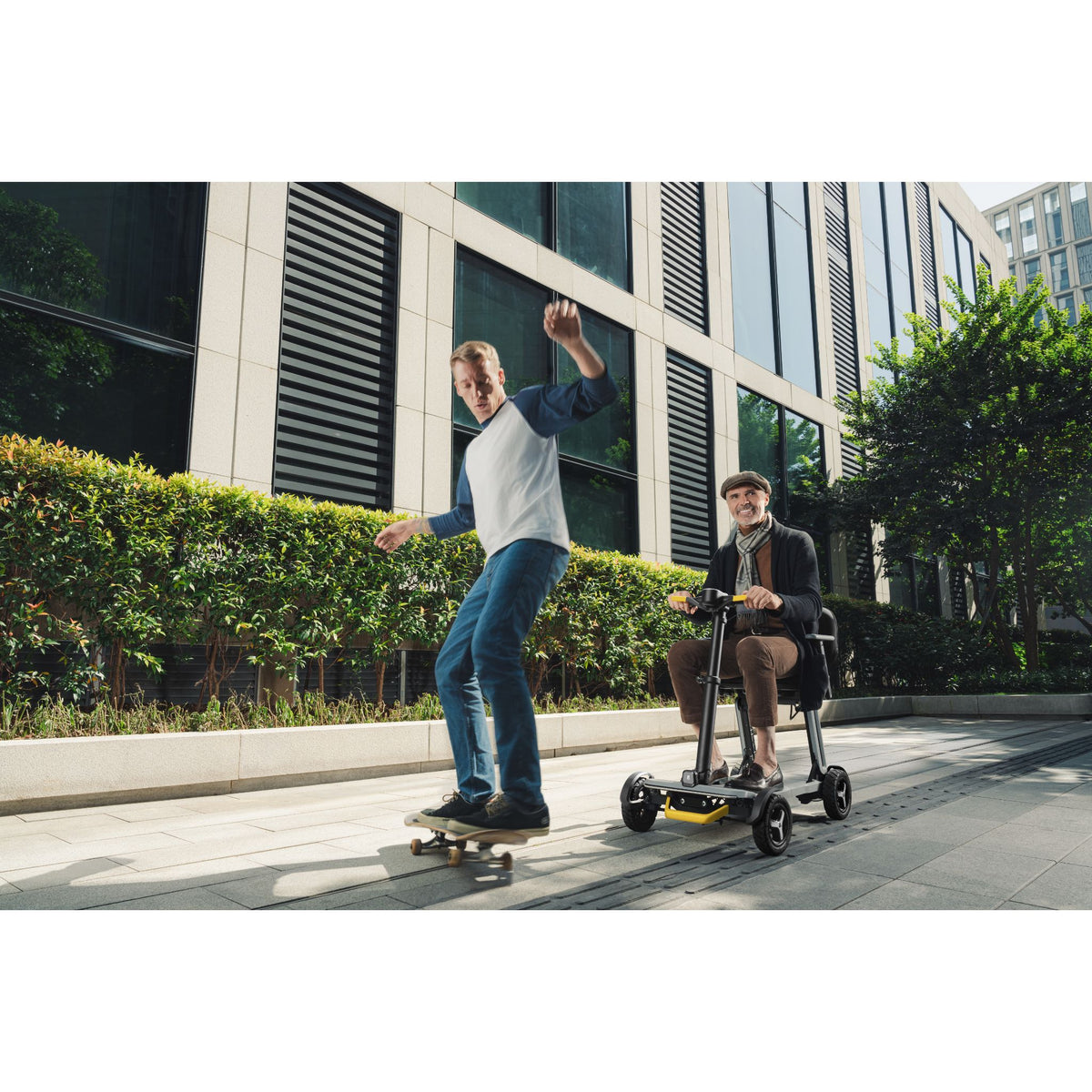 Man riding a Paiseec L5 mobility scooter in Gray along a city sidewalk beside a skateboarder