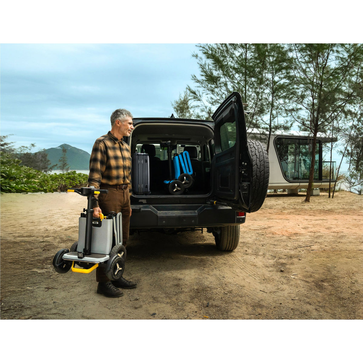 Man lifting a folded Paiseec L5 mobility scooter into an SUV with a second L5 already in the cargo area