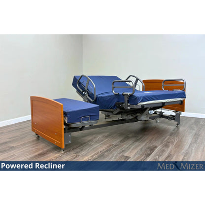 ActiveCare Fixed hospital bed reclined in powered recliner position with side safety rails and cherry wood ends