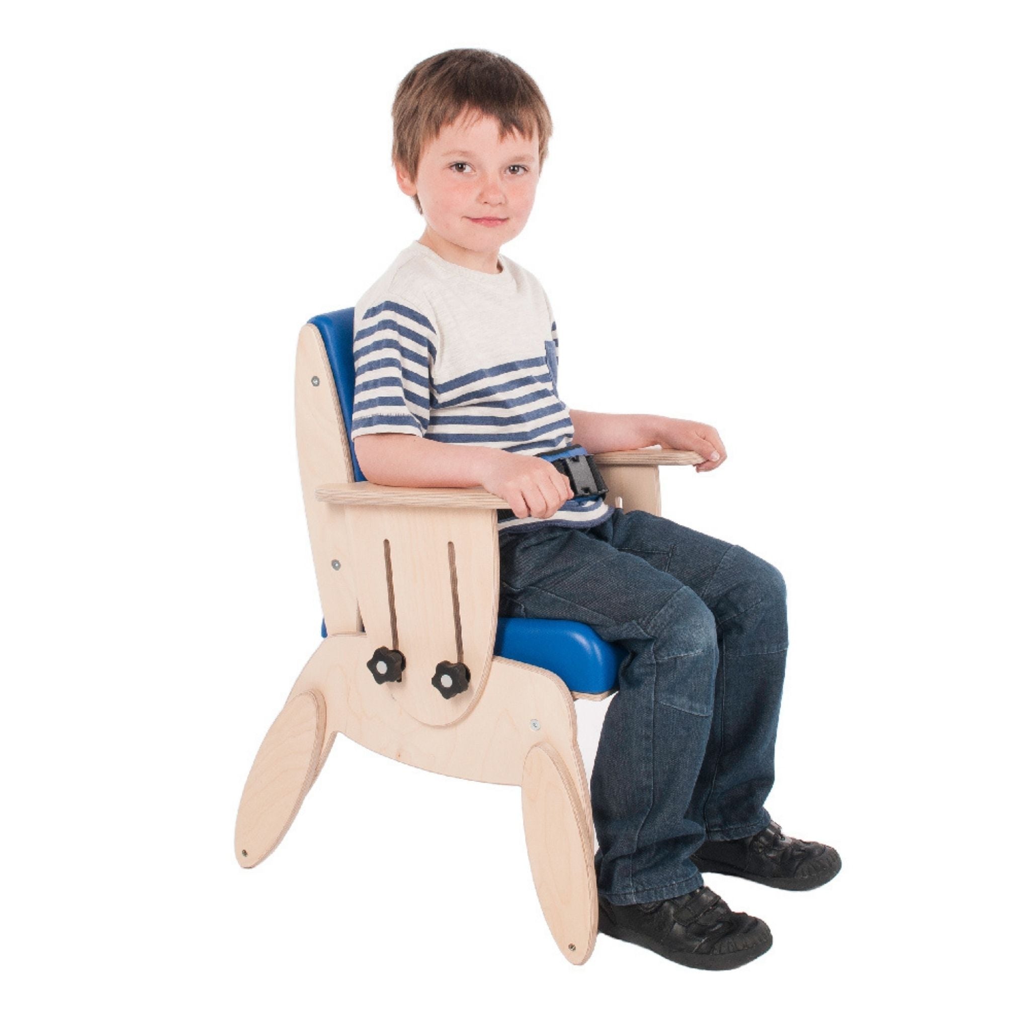 A smiling boy sitting in a blue Smirthwaite Juni postural chair with the padded lap strap fastened.