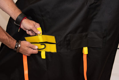 Close-up of a hand opening the Diestco 3-slot cover's hook-and-loop slot to reveal the D-ring strap anchor