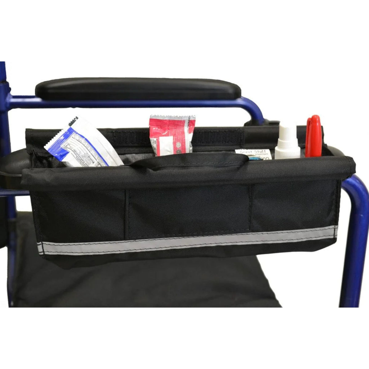 Diestco Armrest Pocket open on a wheelchair armrest holding snack packets, a small bottle, and a pen, showing the hook-and-loop top closure and reflective strip