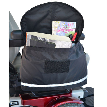 Diestco Deluxe Saddle Bag on an armrest holding a notebook and pens, showing the front and side pockets
