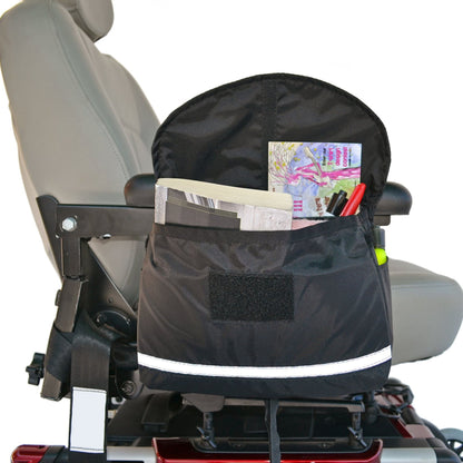 Diestco Deluxe Saddle Bag strapped to a power wheelchair armrest, filled with a notebook, markers, and reflective strip