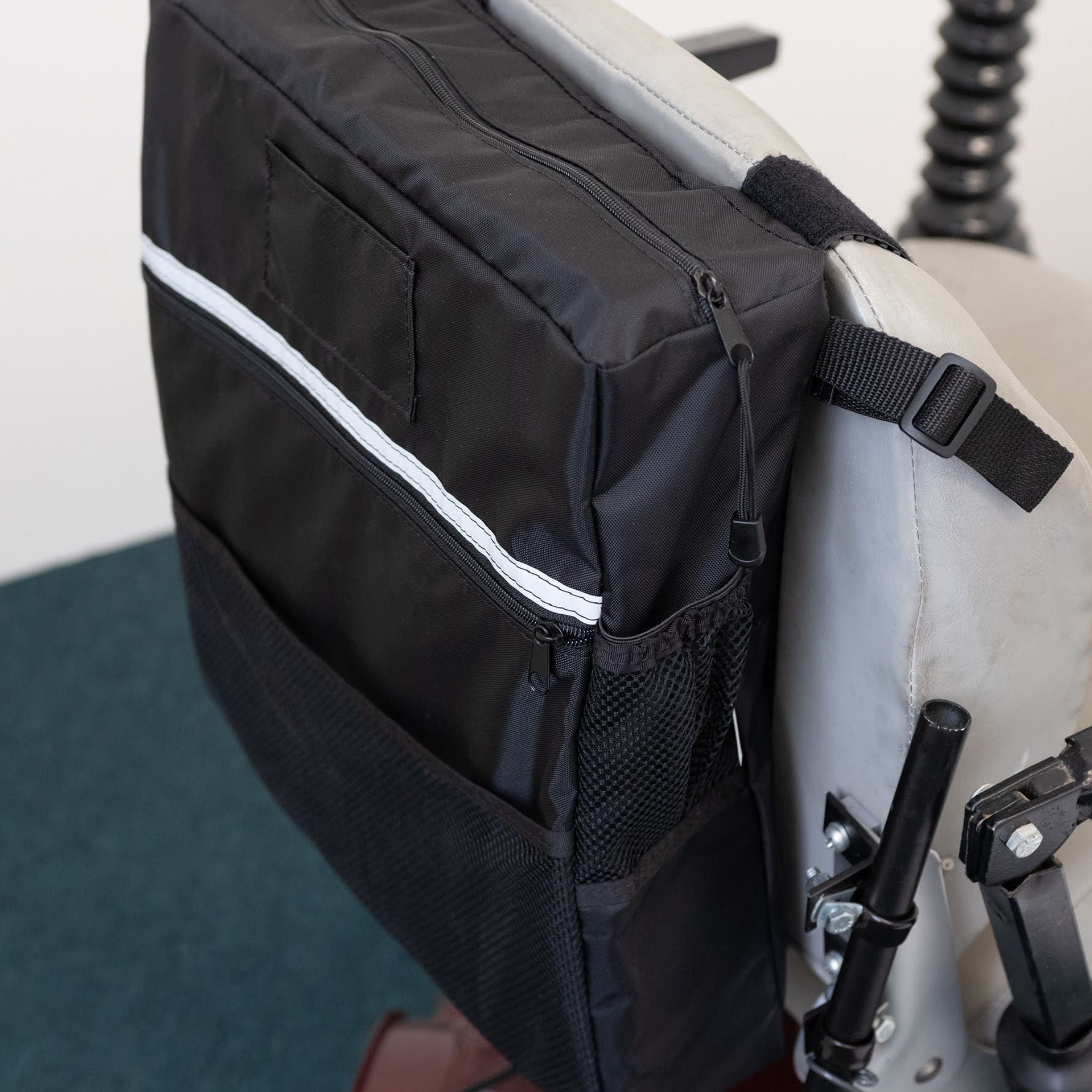 Close-up of the Diestco Mid-Range Seatback Bag zippered pocket, open mesh pocket, ID pocket, and reflective strip