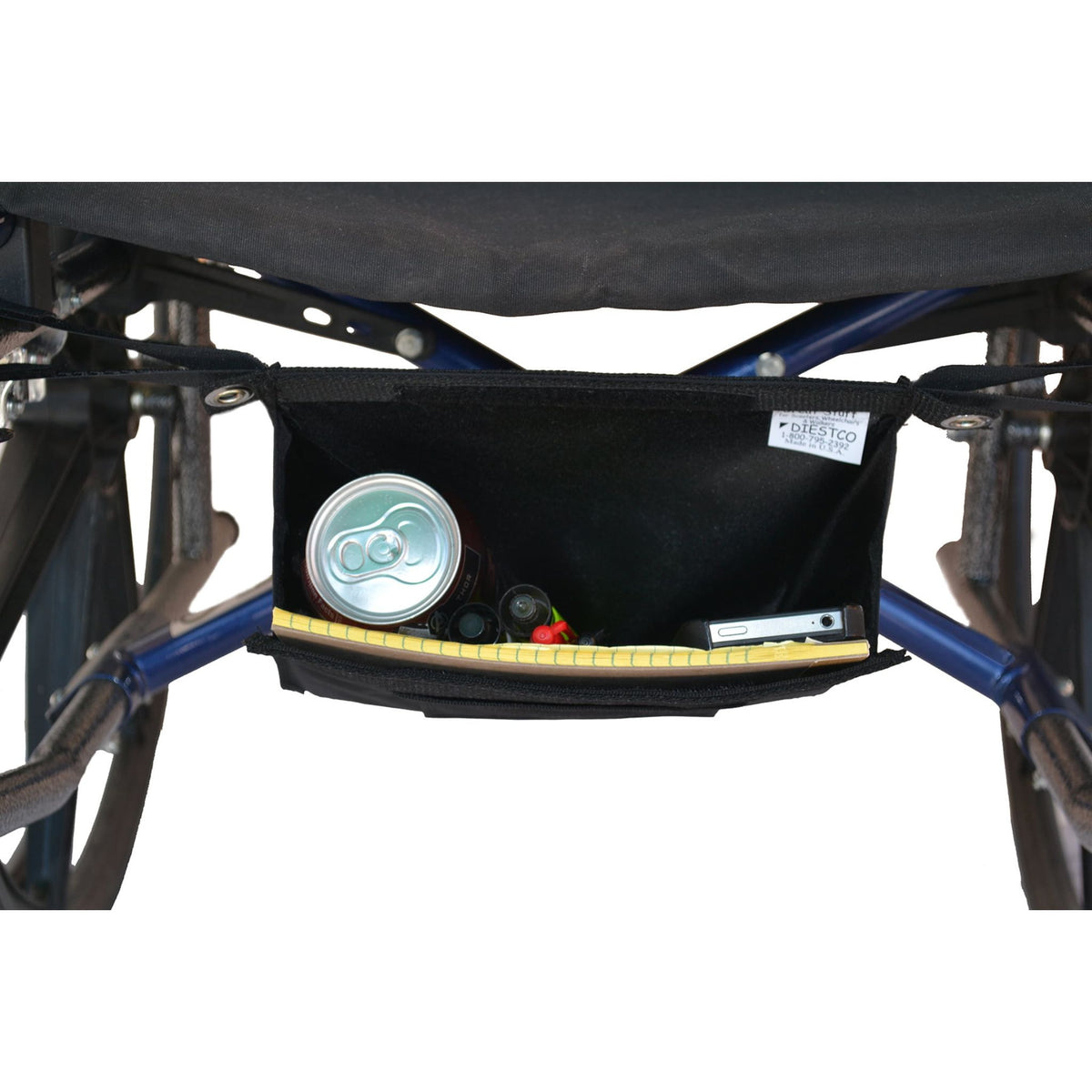 Diestco Small Glove Box strapped under a manual wheelchair seat, open to show a soda can, notepad, pens, and a phone