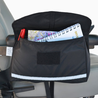 Diestco Standard Saddle Bag on a wheelchair armrest holding a notebook and pen, with an ID pocket and reflective strip