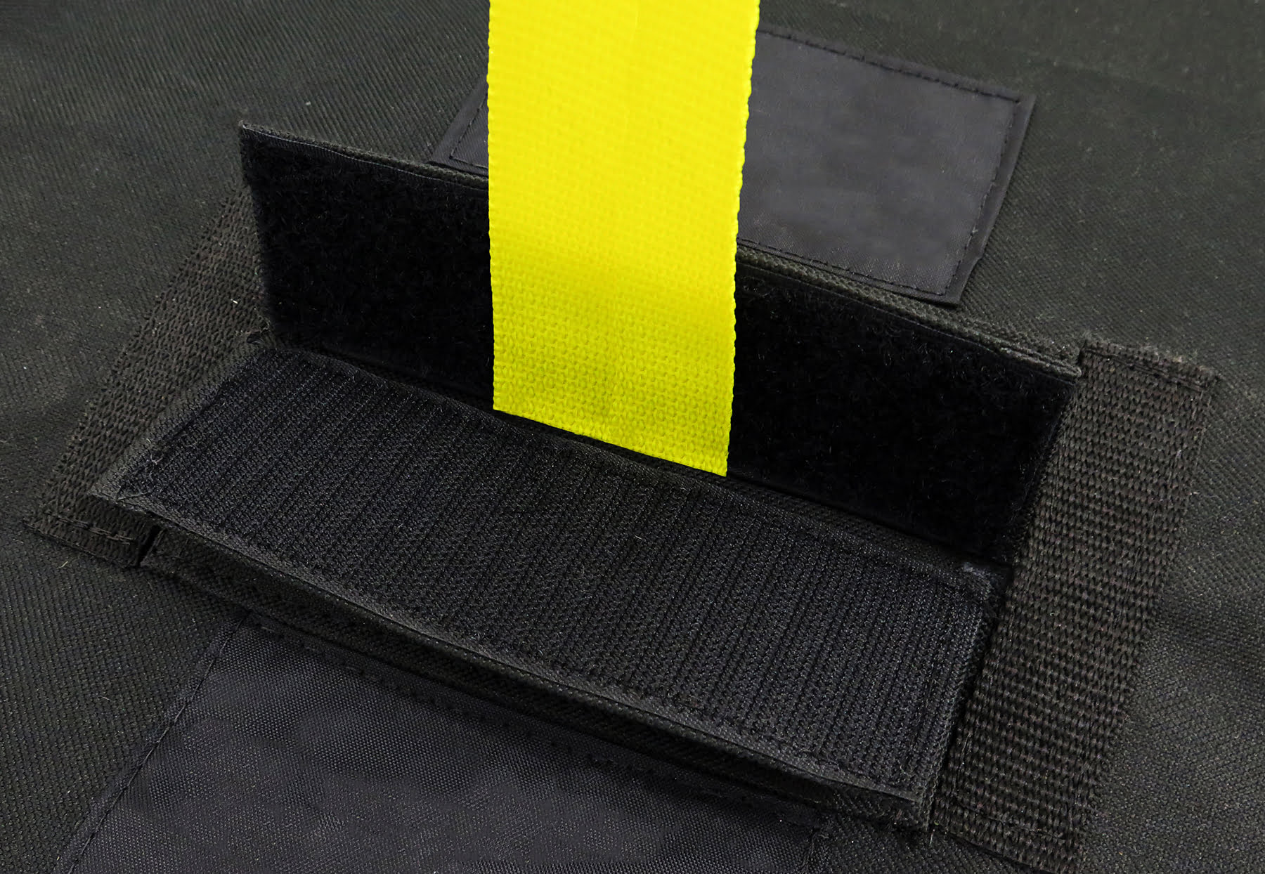 Angled close-up of the Diestco top slit cover showing the hook-and-loop closure and docking strap through the slit