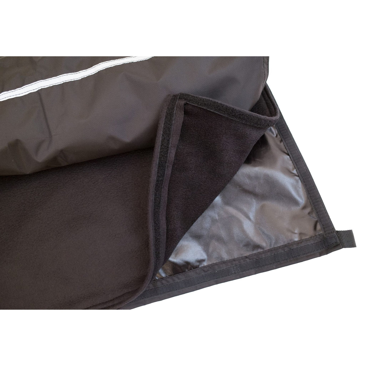 Close-up of Diestco Weather Chaps showing the removable fleece lining, hook-and-loop attachment edge, water-resistant shell, and reflective strip