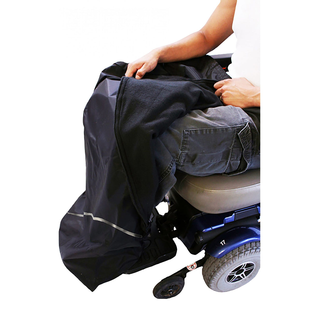 Power wheelchair user wearing Diestco Weather Chaps over their lap and legs, pulling back the shell to show the fleece lining, with reflective strip near the foot pocket