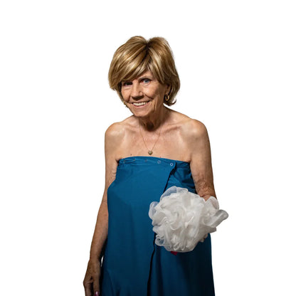Woman wearing blue Dignity Bath & Spa Wrap holding bath pouf during bathing routine