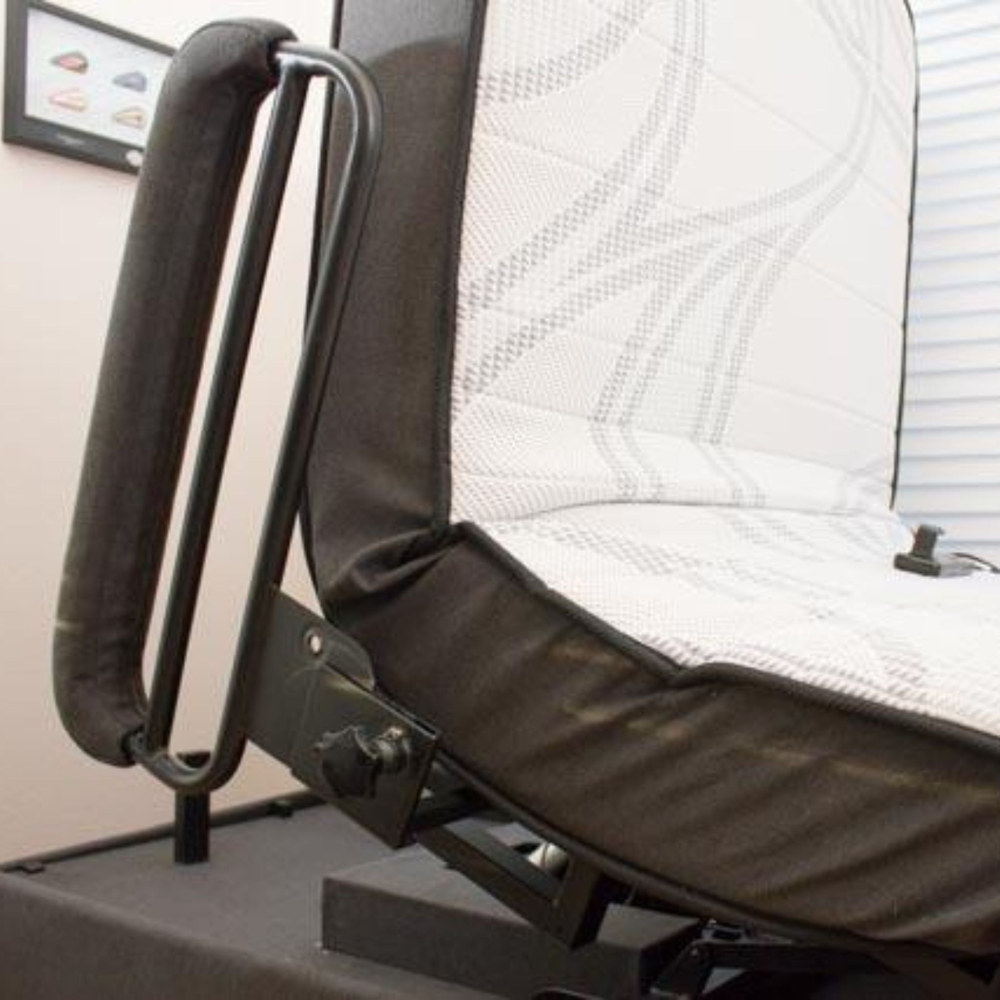 Close-up detail of the ENVYY Sleep-to-Stand adjustable bed by Platinum Health showing the padded safety handrail, reinforced frame construction, and supportive mattress system designed for safer bed transfers and user stability.