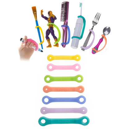 EaZyHold Teacher and Therapist 7-Pack silicone cuffs shown holding a paintbrush, toy, hairbrush, electric toothbrush, fork, and spoon, with all seven color-coded straps below