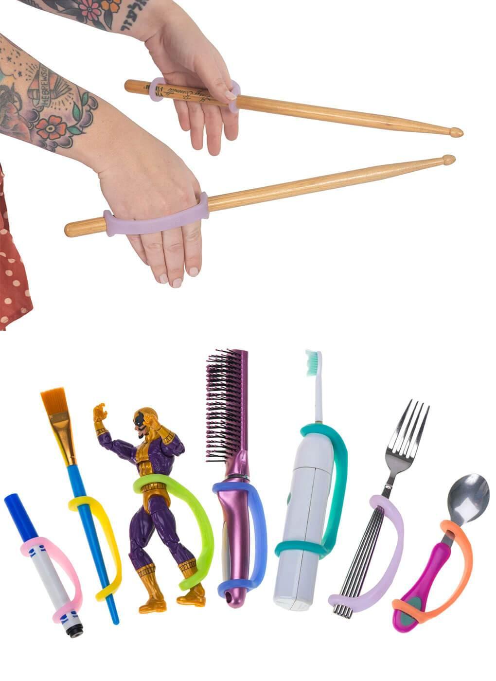 Adult using purple EaZyHold cuffs to grip two wooden drumsticks, above a lineup of cuffs holding everyday tools and utensils