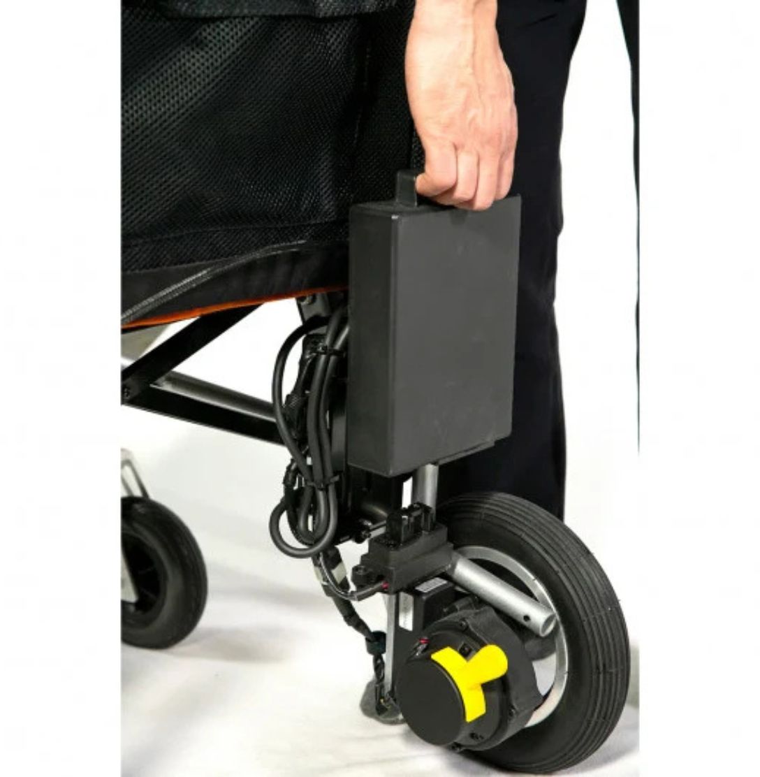 Hand lifting the removable lithium battery pack off the back of the Feather Power Chair by its handle