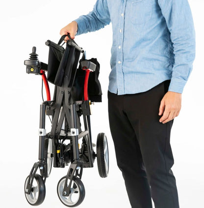Man lifting the folded 33 pound Feather Power Chair by its handle with one hand