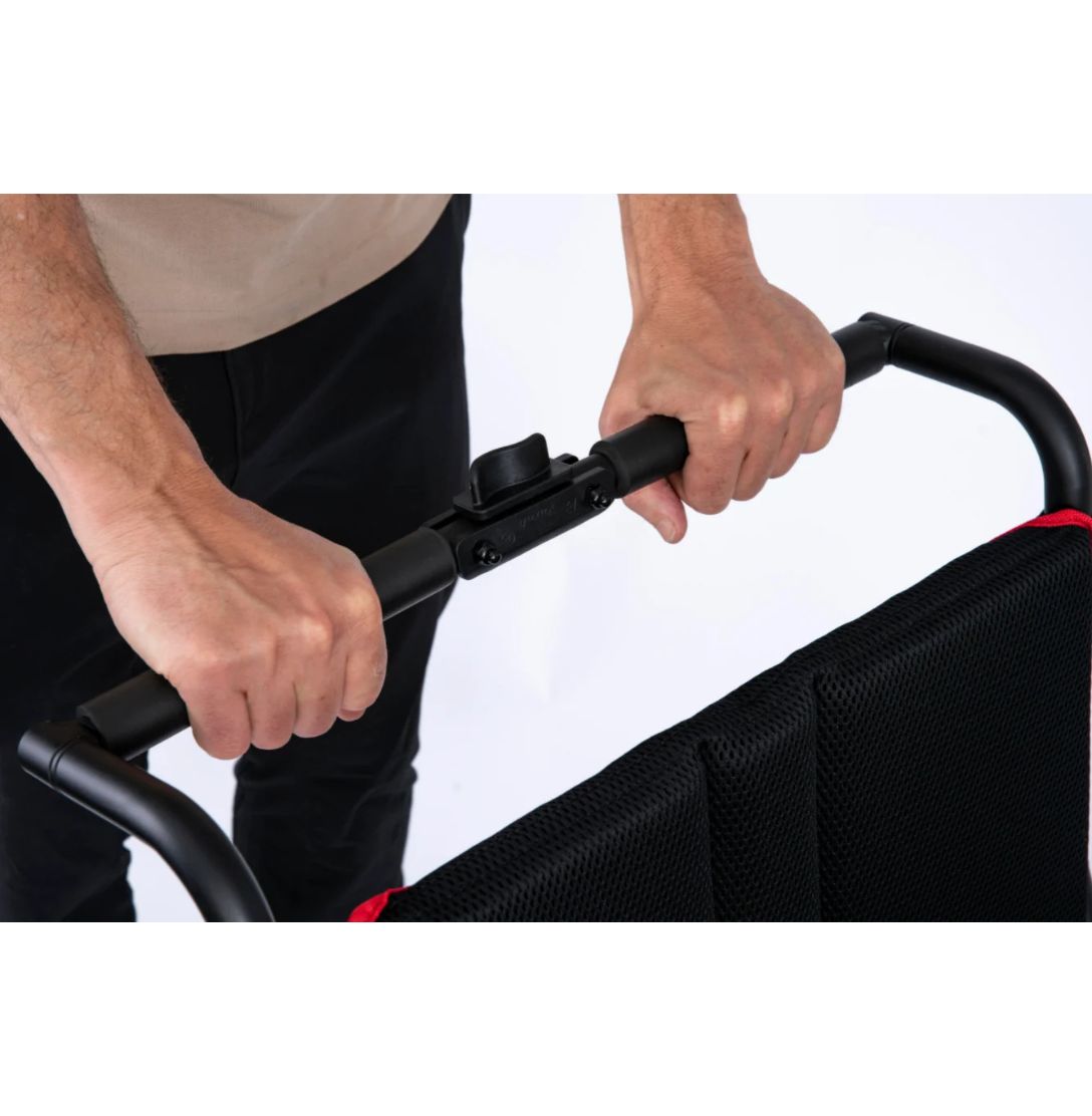 Hands gripping the Feather Power Chair push handle with its center release latch and mesh backrest
