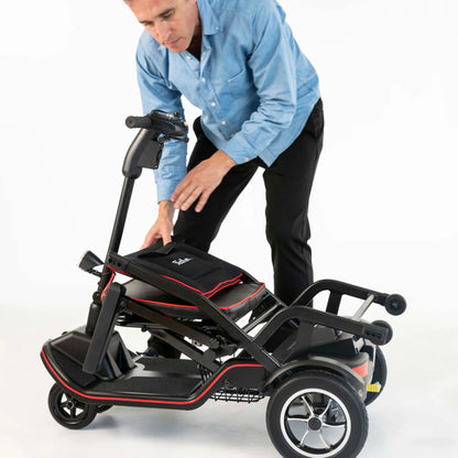 Man lowering the Feather Scooter tiller down over the folded seat to complete the fold