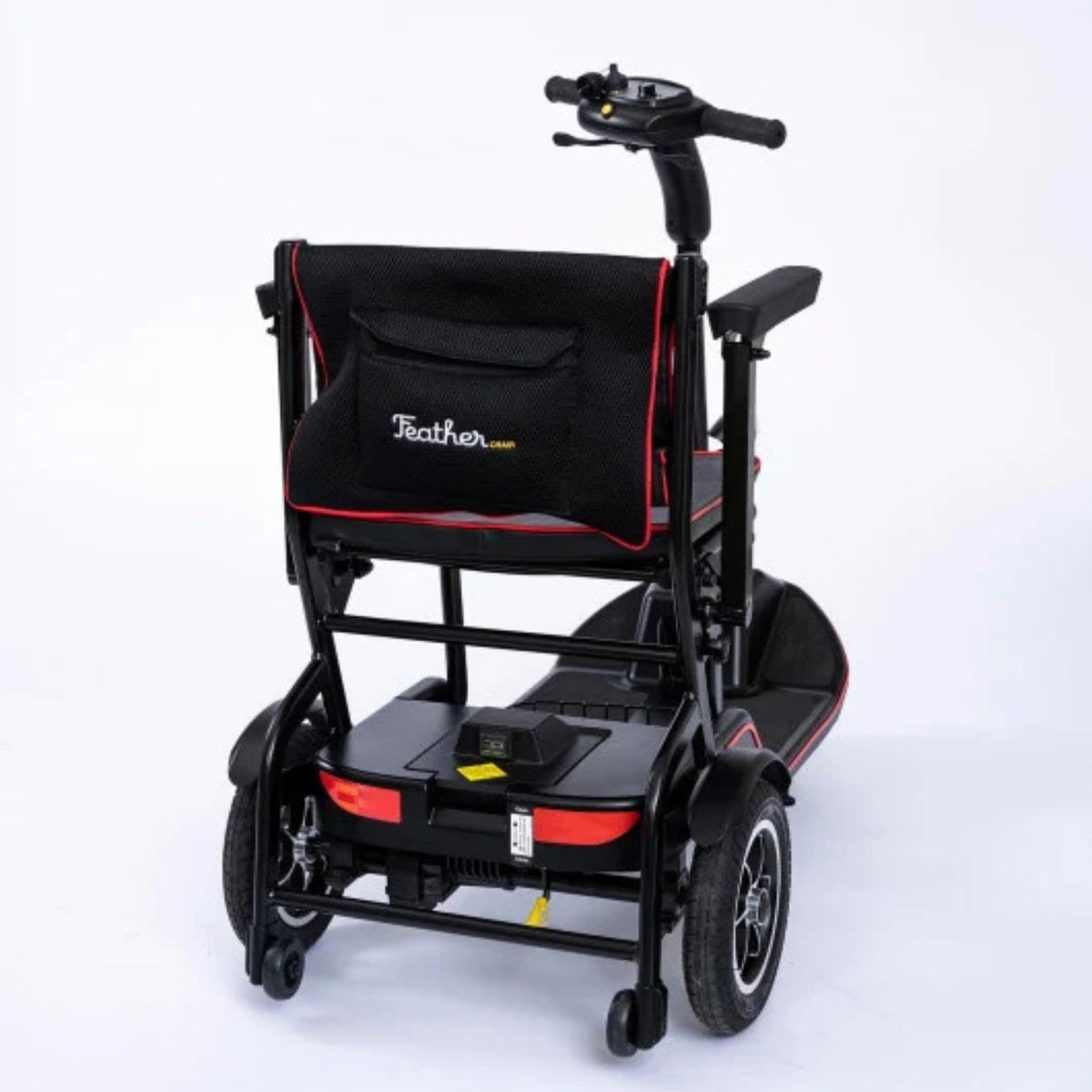 Rear three-quarter view of the Feather Scooter showing the seatback pocket, rear wheels, anti-tippers, and tiller