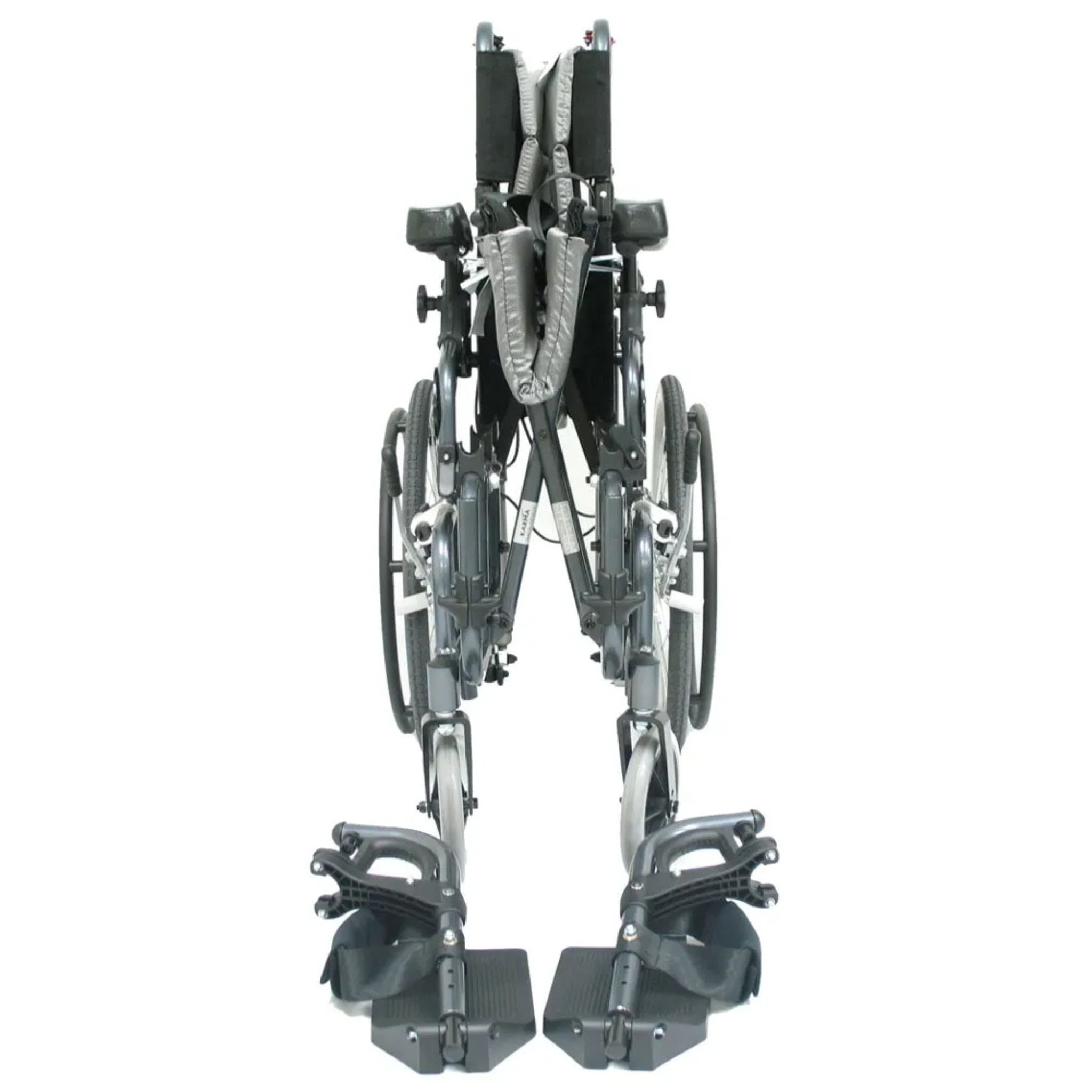 Front view of the folded Karman VIP-515 manual propel tilt-in-space wheelchair with Leg rests showing compact folding frame for transport and storage on a white background