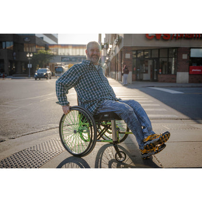 A man in a wheelchair outside in front of a pharmacy using an Ease Gen 2 cushion