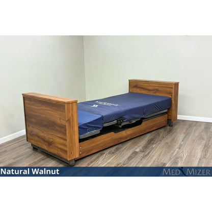 Med-Mizer ActiveCare Deluxe rotating pivot home care bed in Natural Walnut, lowered flat with a blue mattress