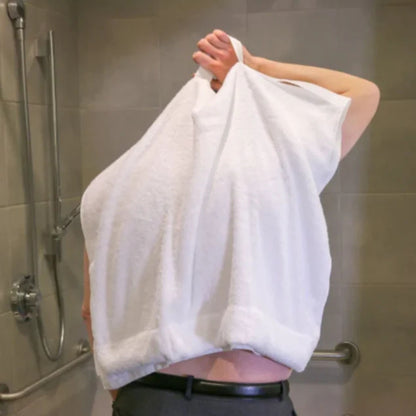 Person using the Mobility Towel by Kay Inspired to dry their back independently by pulling the sewn handles over the shoulders.