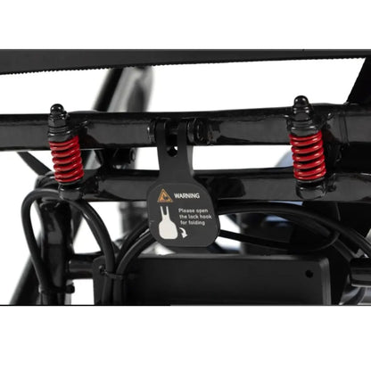Close-up of the MM60 Carbon folding lock hook, red suspension springs, and folding warning label