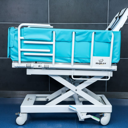 Side view of Morgan AH Medical bathing trolley with padded safety rails and lift frame