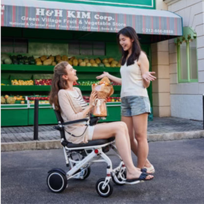 User in the OAS Air Pro lightweight folding electric wheelchair shopping outside a neighborhood market