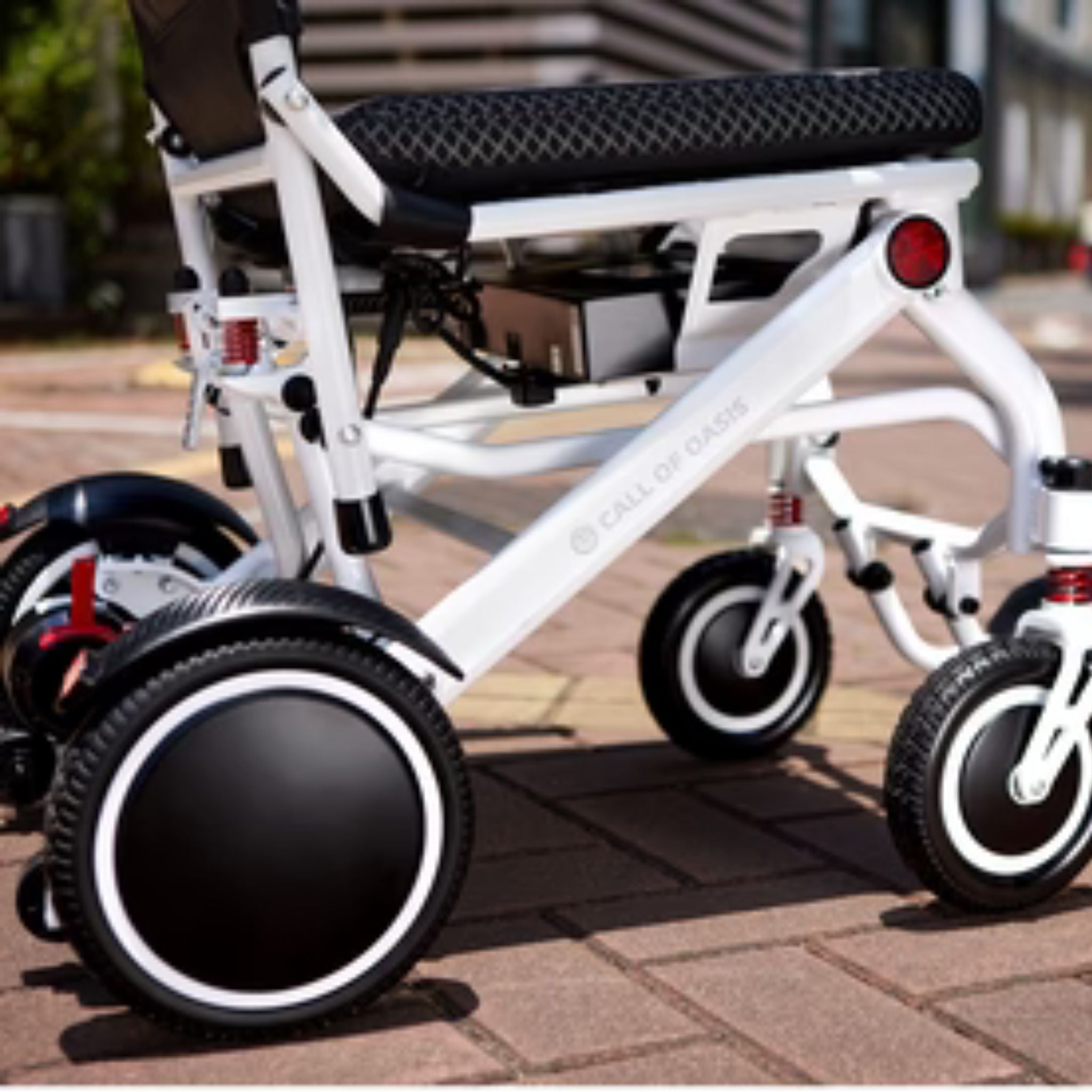 Close-up side view of the OAS Air Pro lightweight folding electric wheelchair aluminum frame and suspension