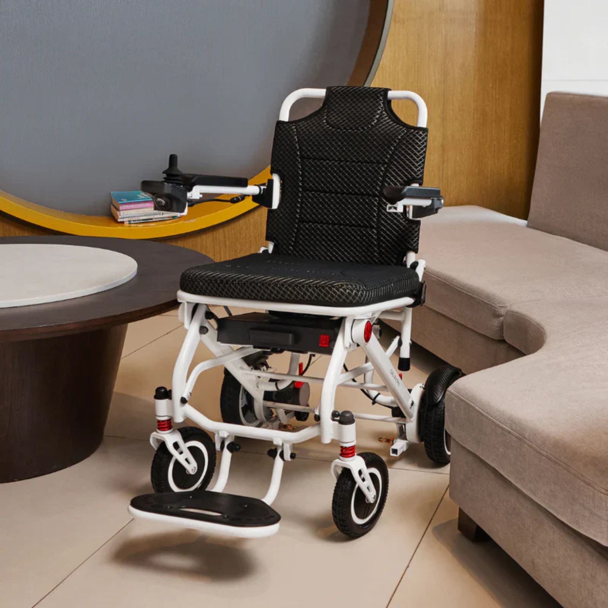 OAS Air Pro lightweight folding electric wheelchair positioned indoors between living room furniture