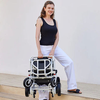 Person carrying the folded OAS Air Pro lightweight folding electric wheelchair by its integrated handle