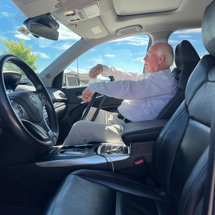 Man sitting inside a car with a clear sky visible through the windows