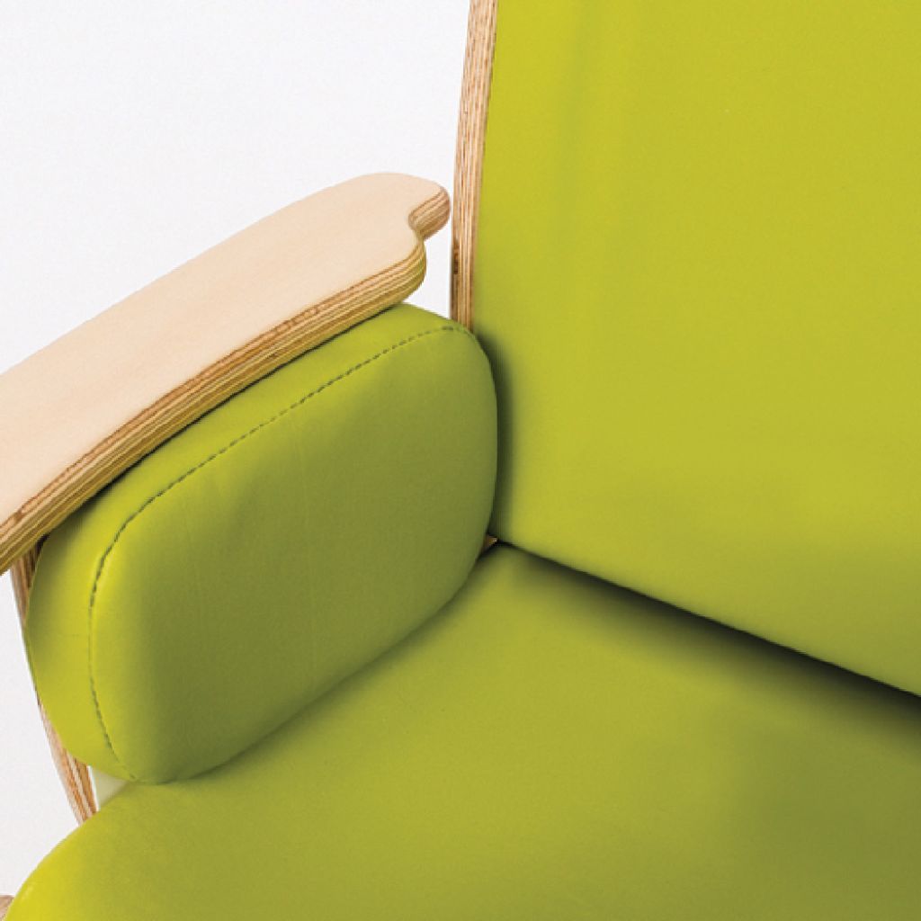 Green side-support cushion fitted to a Smirthwaite Juni chair to add hip and thigh support.