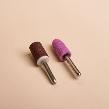 Close-up of two Soulo replacement tips, a brown sanding band and a pink grinding stone tip