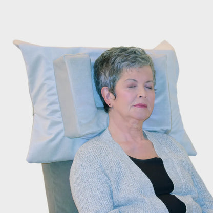 Woman relaxing in a recliner using Tausi Horizontal Support System for neck support