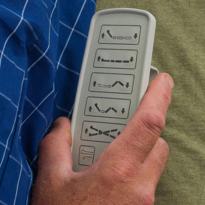 Close-up of a hand holding the Night Rider HD wired pendant control with head, foot, and height buttons
