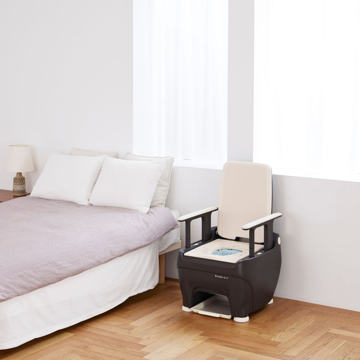 Wrappon ORB portable toilet placed beside a bed for easy nighttime bedroom use