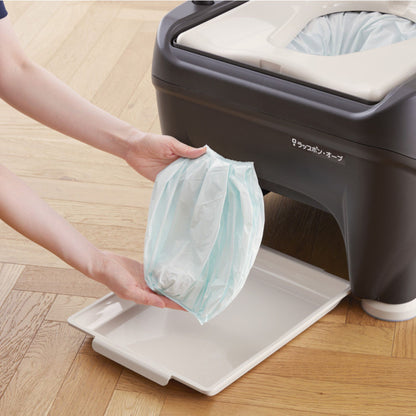 Caregiver removing sealed Wrappon ORB waste bag after automatic wrapping cycle for cleaner disposal