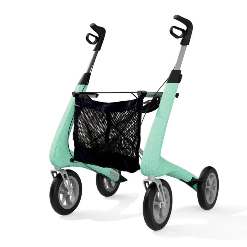 Angled view of a green byACRE Carbon Ultralight rollator with the black mesh storage bag mounted under the seat
