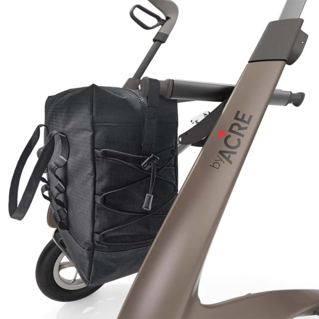 Charcoal byACRE Daypack bag attached to the side of a bronze byACRE rollator frame, shown in use